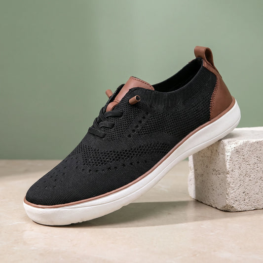 Black knit lace-up shoe with a white sole on a limestone block