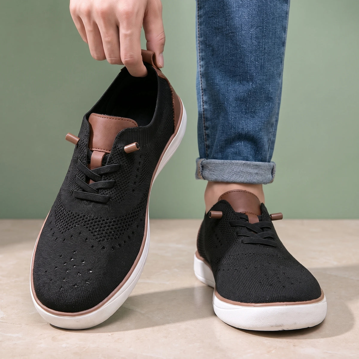 Man lifting one shoe by the heel tab while wearing the other