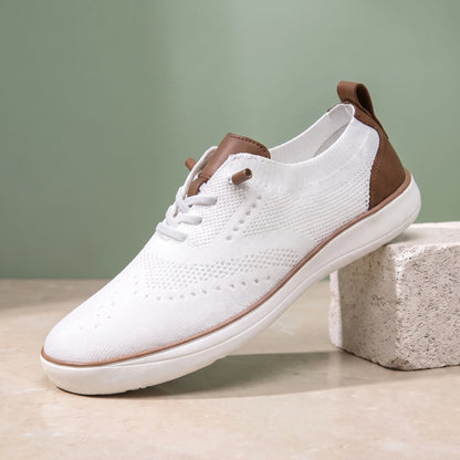 White knit lace-up shoe with a white sole on a limestone block