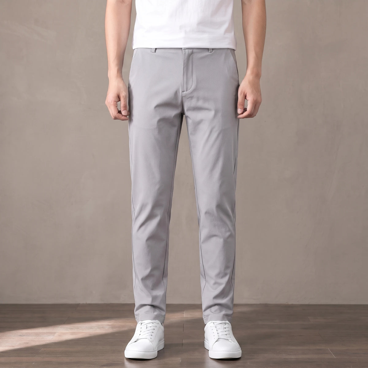 light grey tapered trousers worn with a white tee and white trainers