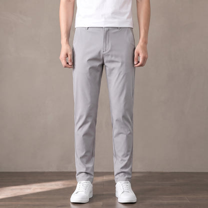 light grey tapered trousers worn with a white tee and white trainers