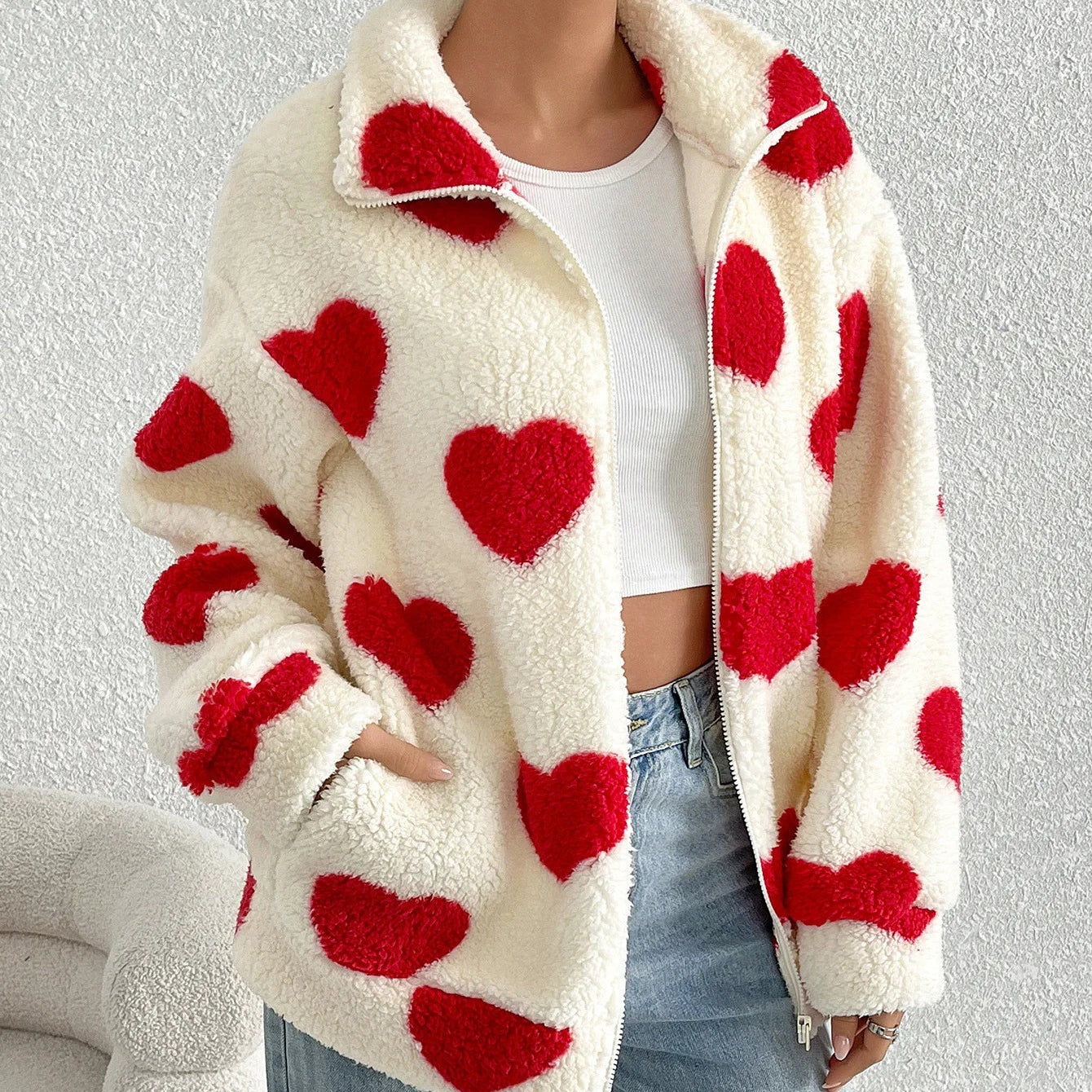 Person wearing a white coat with red heart patterns on a light gray background